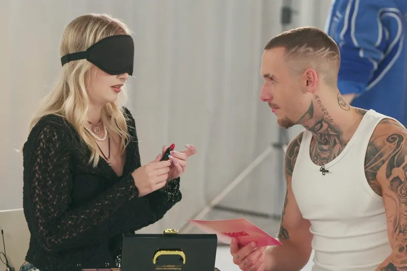Still from Amorki: a blindfolded girl and a young man on a blind date in the studio