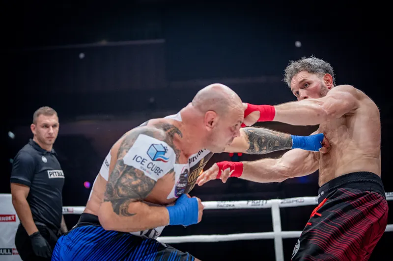 Two fighters trading punches at a Fight Mode gala, referee at the ropes